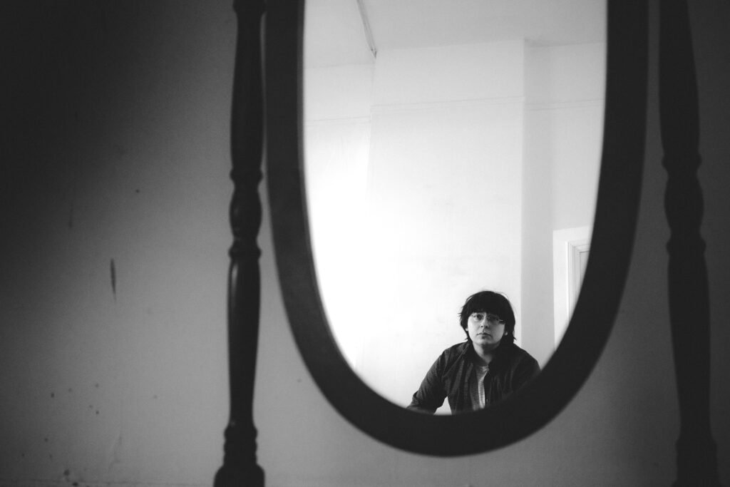 Photo of Tristan Konkle looking into a mirror